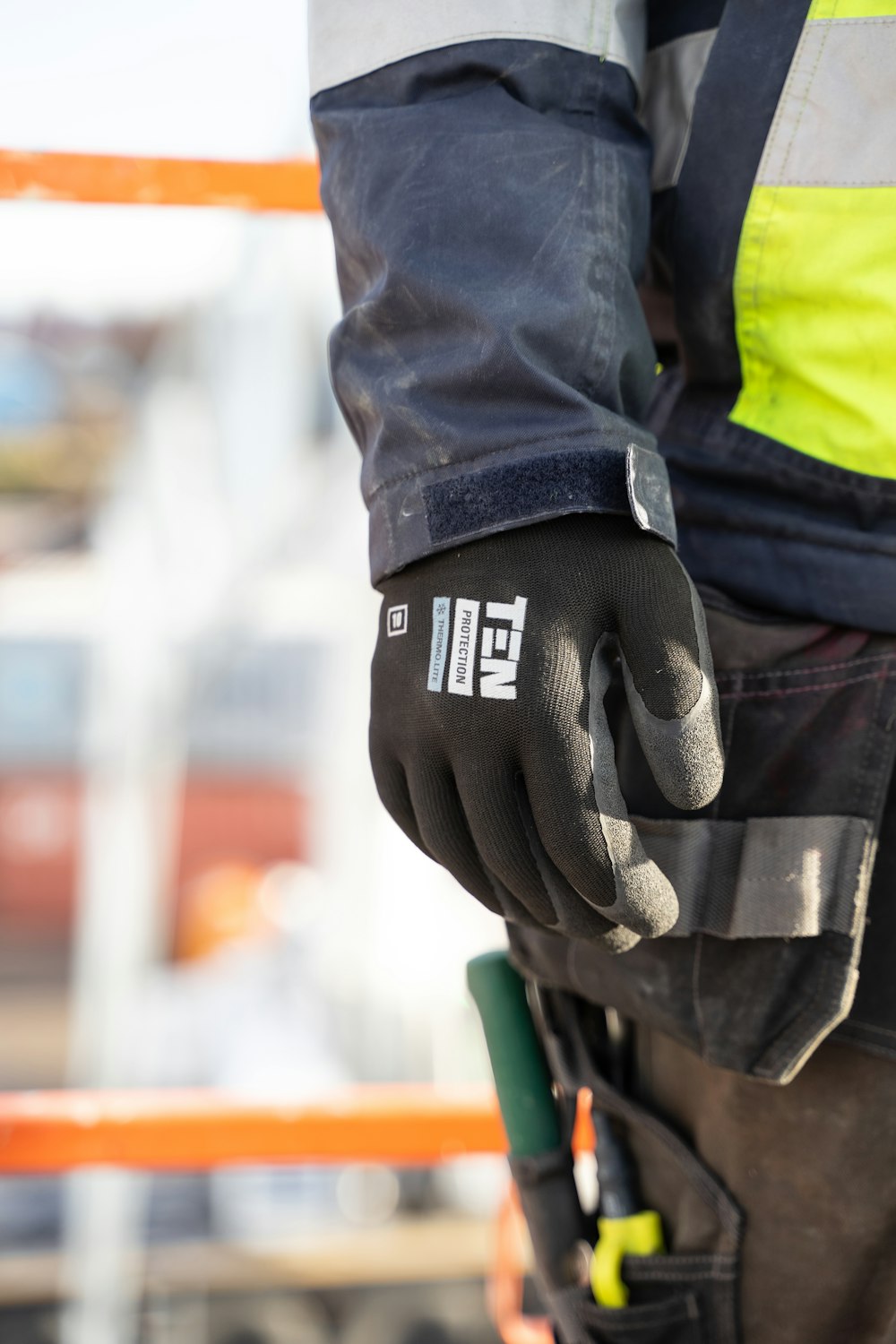 a person wearing a safety jacket and gloves