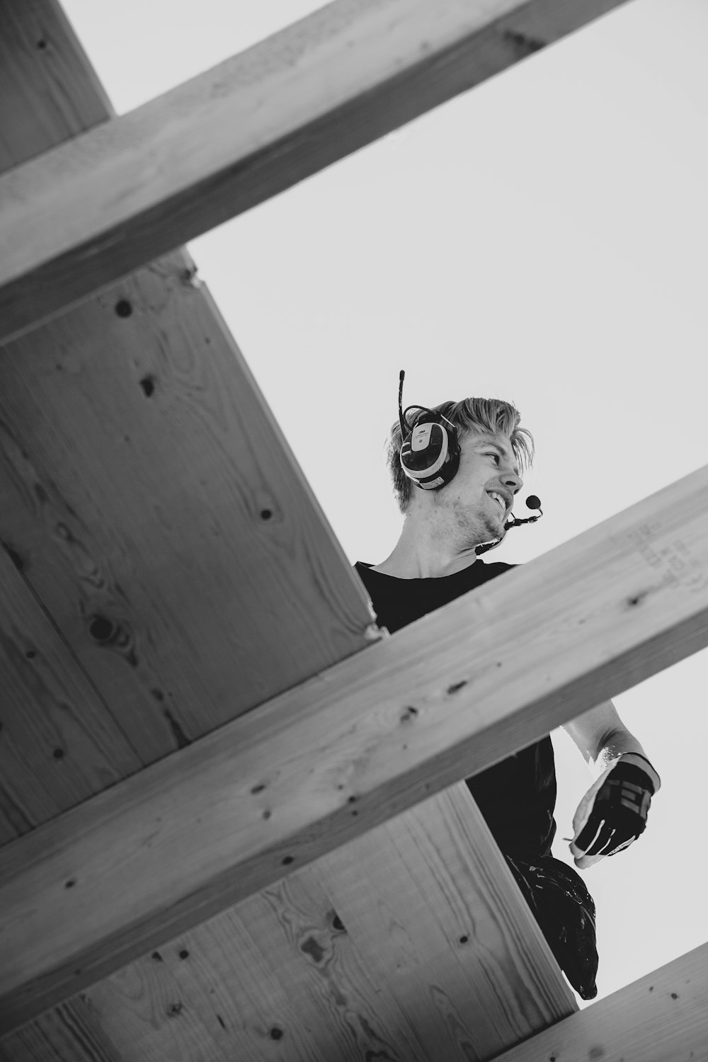 木造の建物の上に立つヘッドフォンを着た男性
