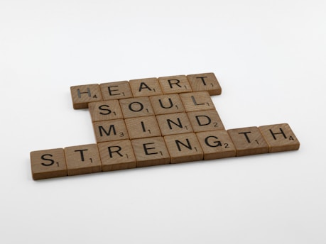 two scrabble tiles spelling the words heart, soul, mind, and strength