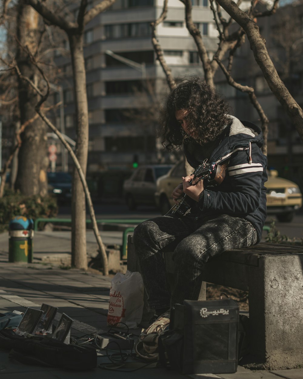 a man sitting on a bench with a cell phone