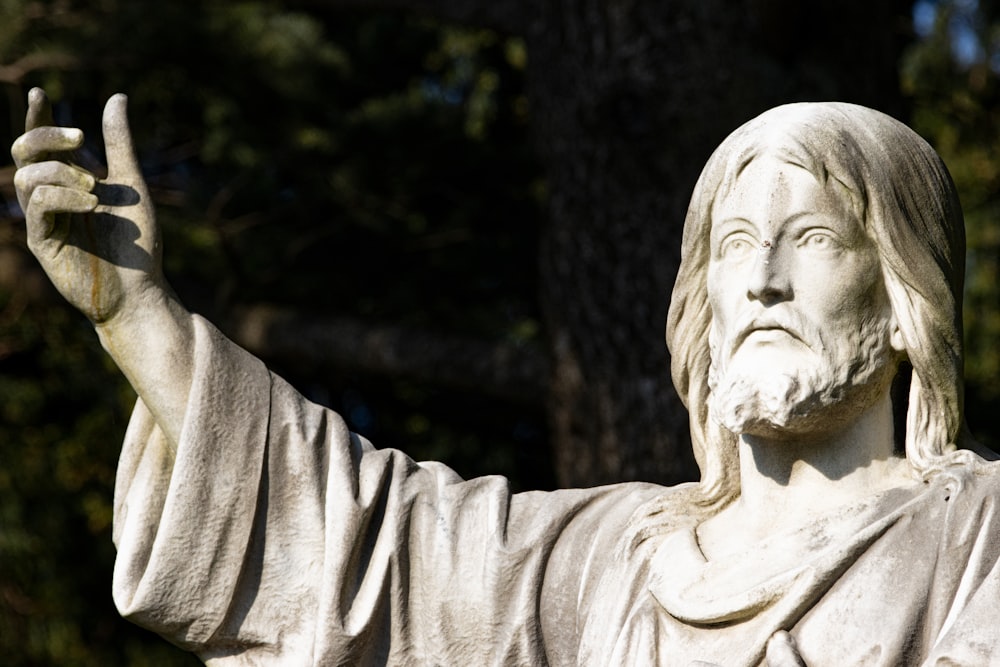 a statue of jesus holding a peace sign