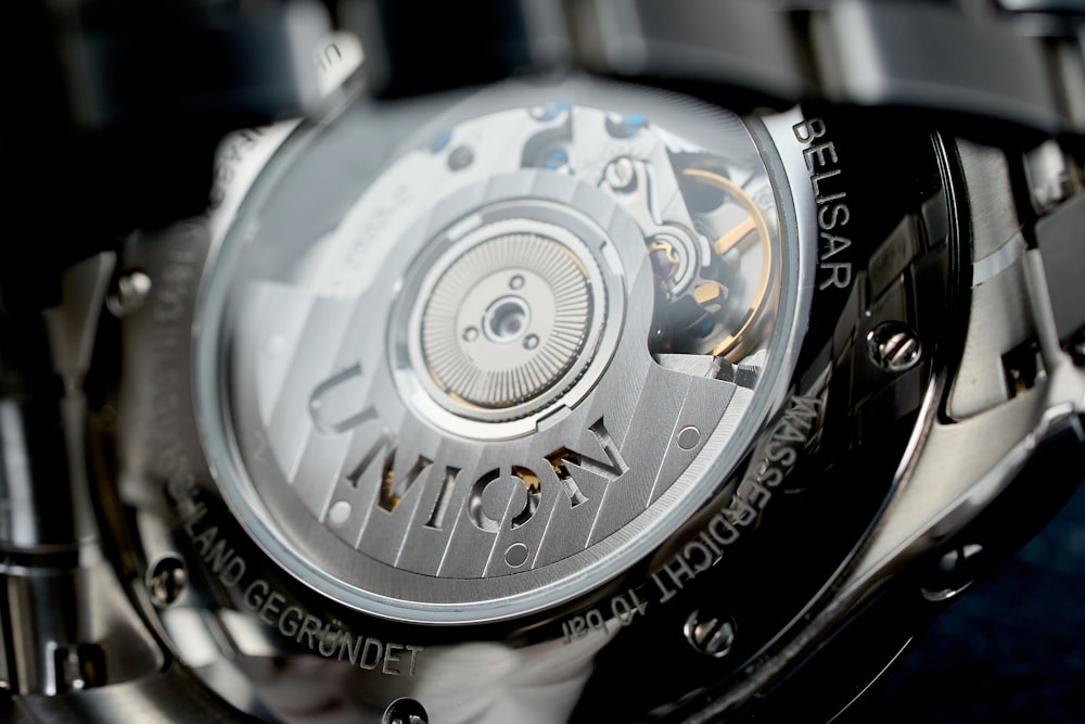 a close up of a watch on a black watch face