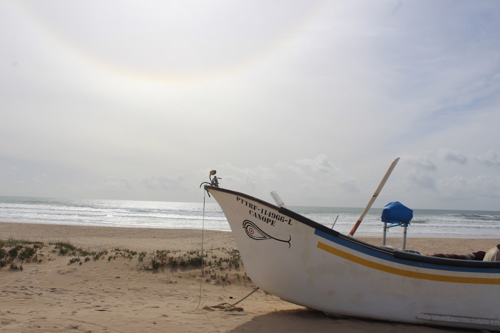 a boat on the beach with a rainbow in the sky