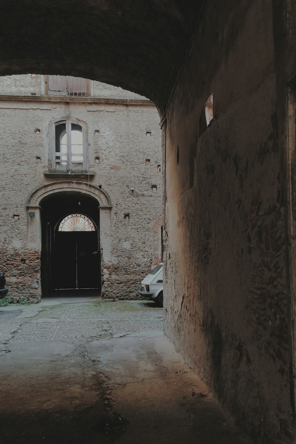 a dark alley way with cars parked in it