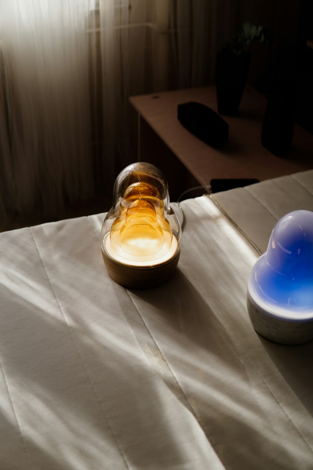 a glass bottle sitting on top of a bed