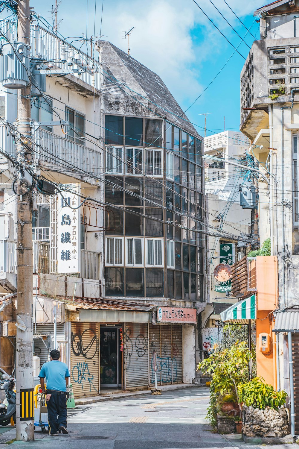 a man walking down a street next to tall buildings