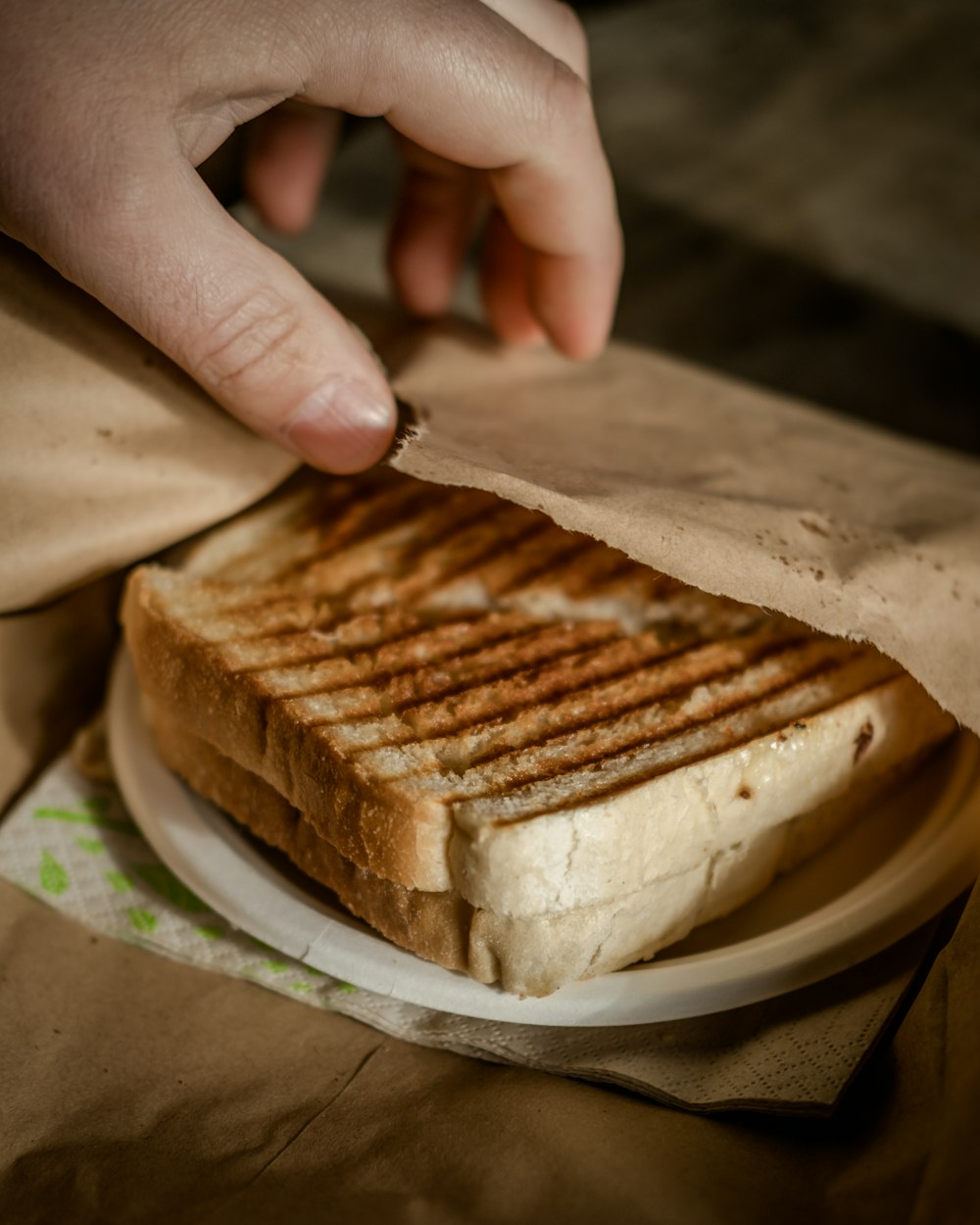 a sandwich on a plate being held by a person