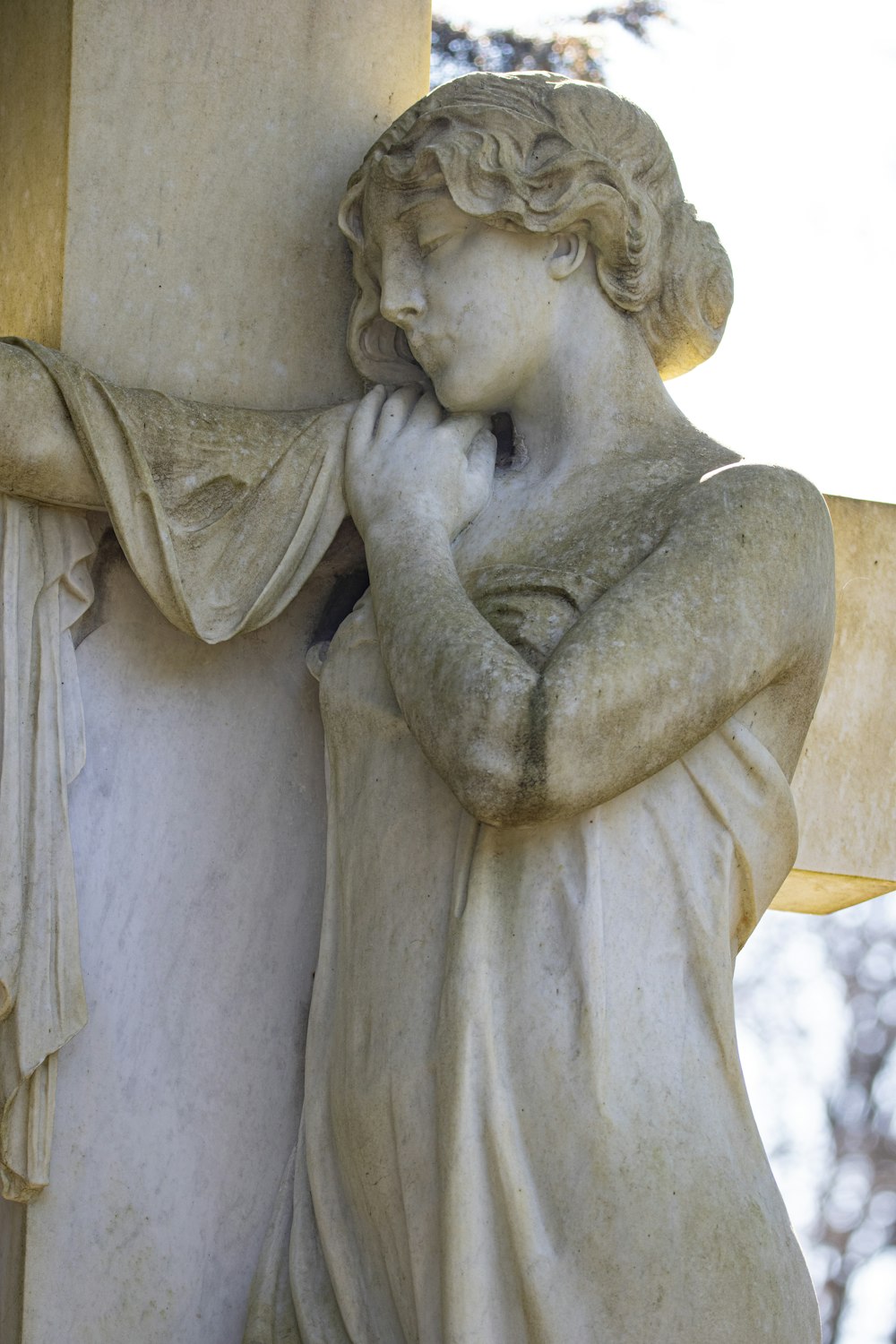 a statue of a woman leaning against a pillar