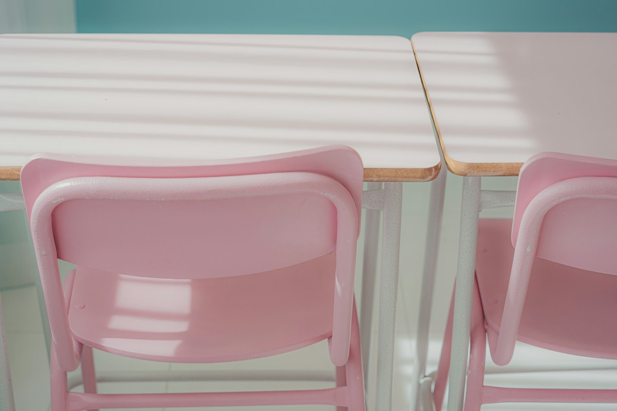 Two pink chairs at a table, ideal for planning 100th day of school shirt ideas and activities.