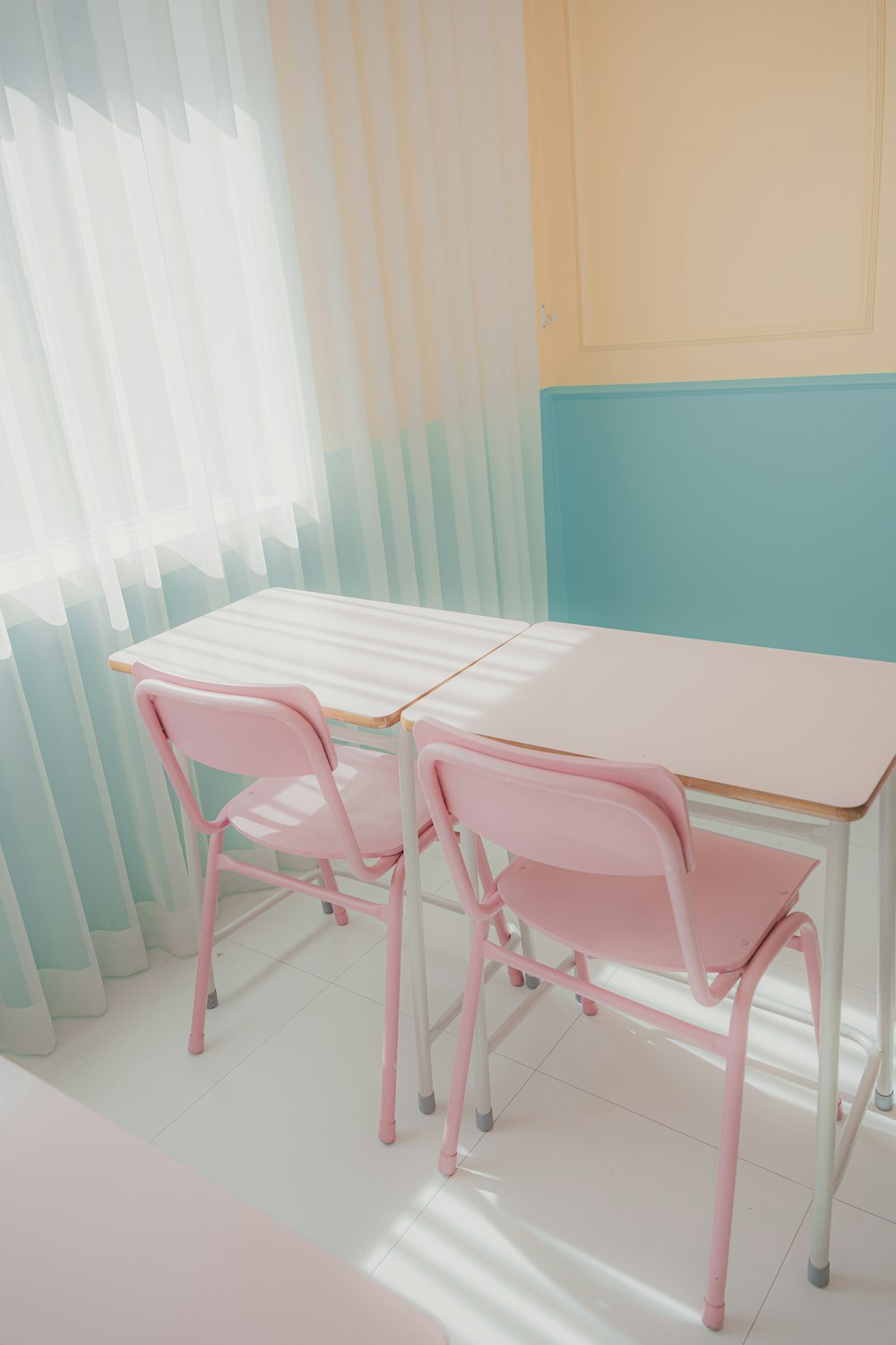 a pink table and two pink chairs in a room