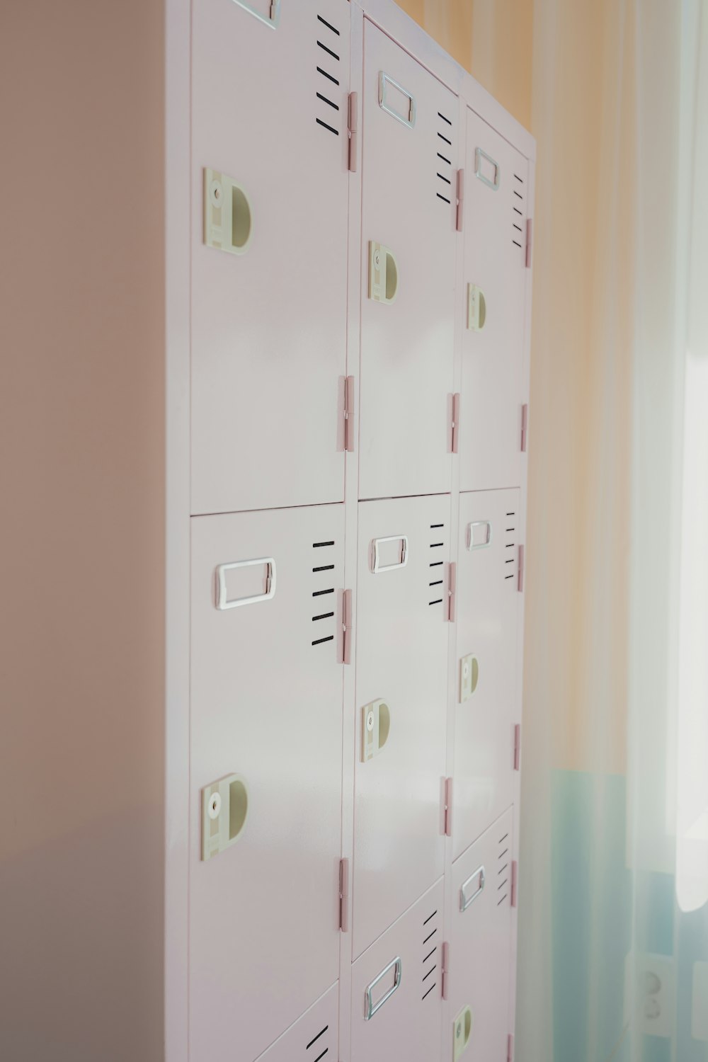 a row of white lockers sitting next to a window