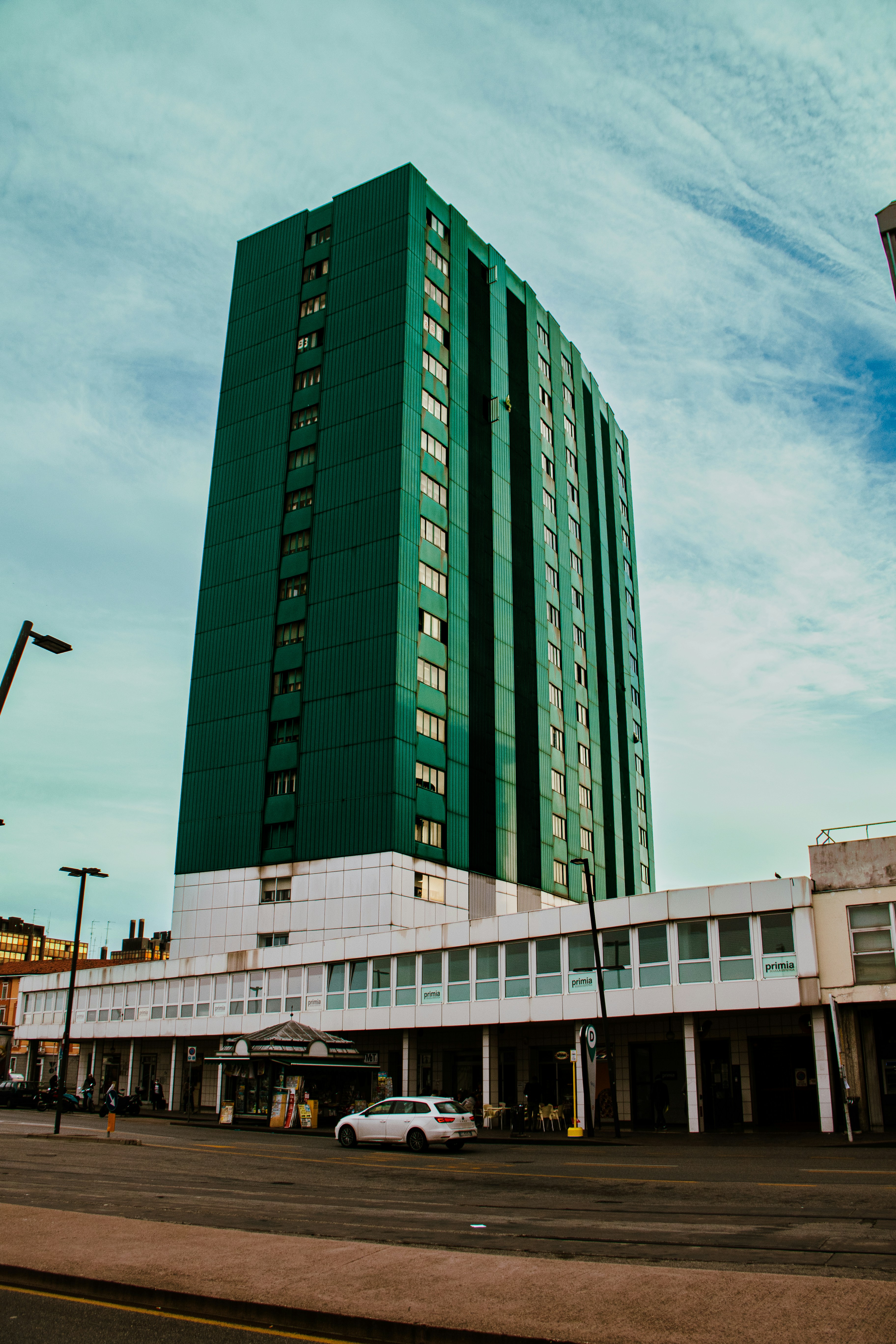 a tall green building sitting on the side of a road