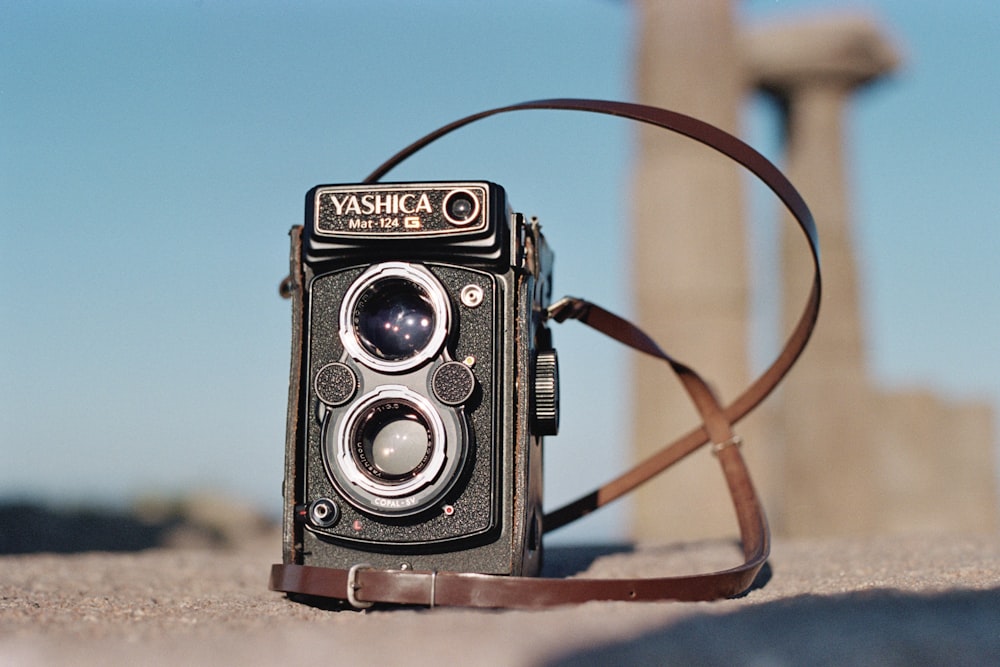 Una macchina fotografica vecchio stile seduta a terra