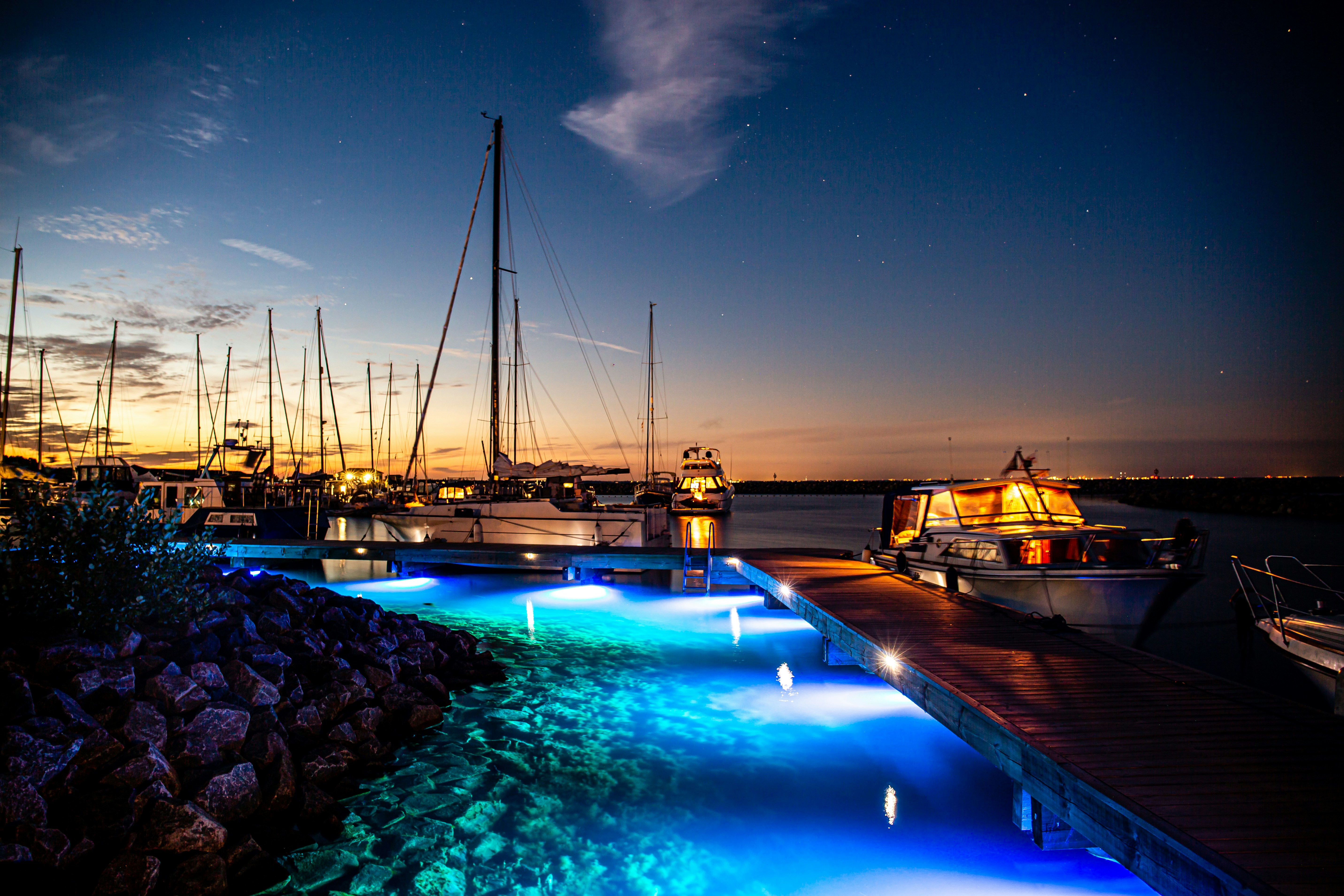 Foto zum Thema Ein Dock mit Booten und Lichtern in der Nacht ...