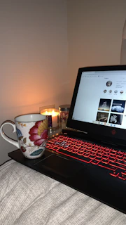 A warm, pink-toned cozy corner with a laptop playing a personal vlog video