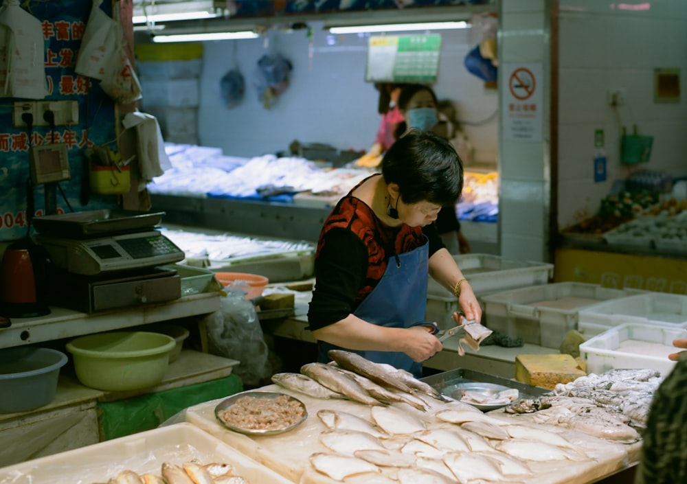 a woman in a kitchen preparing food on a cutting board