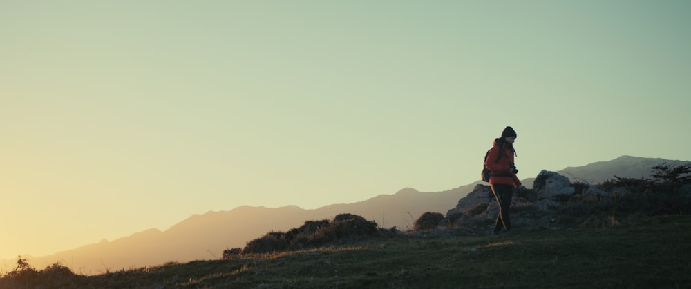 a person standing on top of a grass covered hill