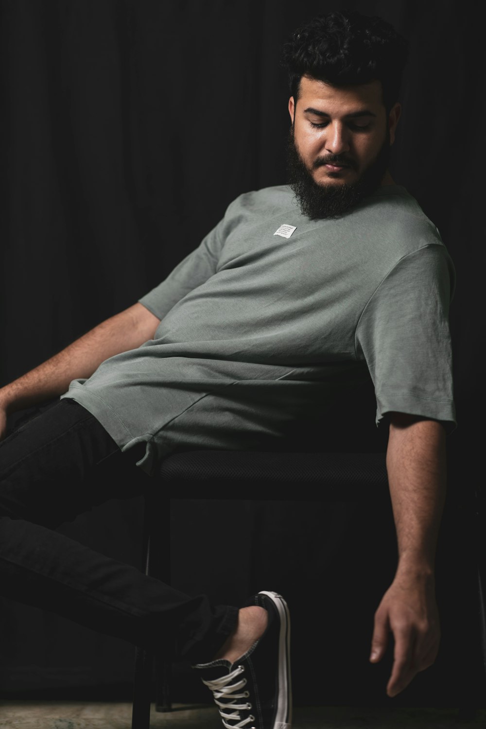 a man with a beard sitting on a chair