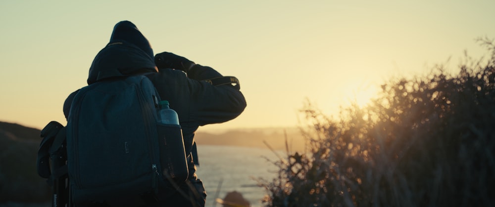 a person with a backpack looking out at the ocean