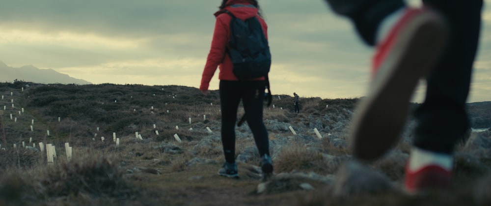 Eine Person, die mit einem Rucksack auf einem Hügel steht