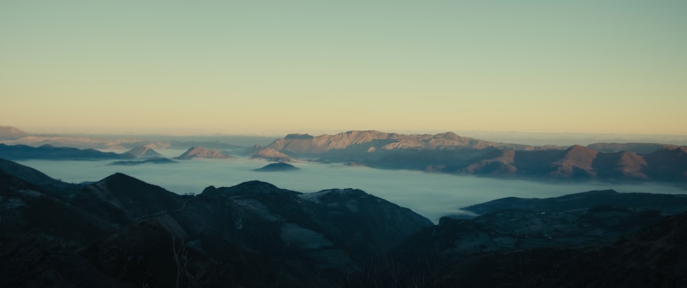 a view of a mountain range with low lying clouds