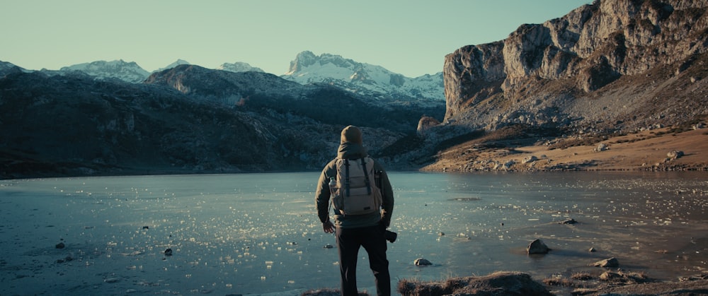 a man standing on the edge of a body of water