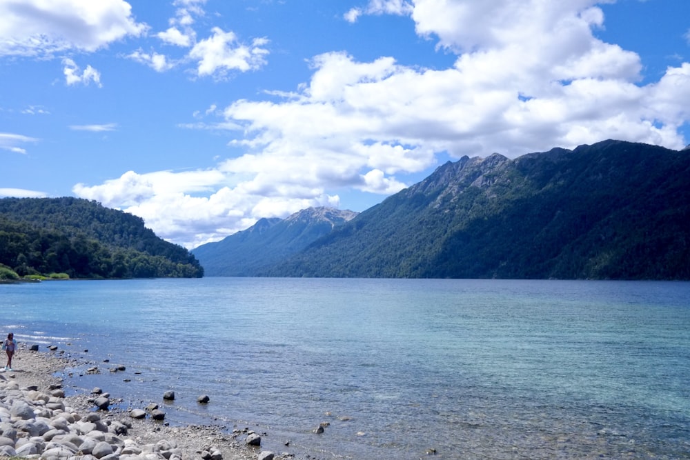 a person standing on the shore of a lake