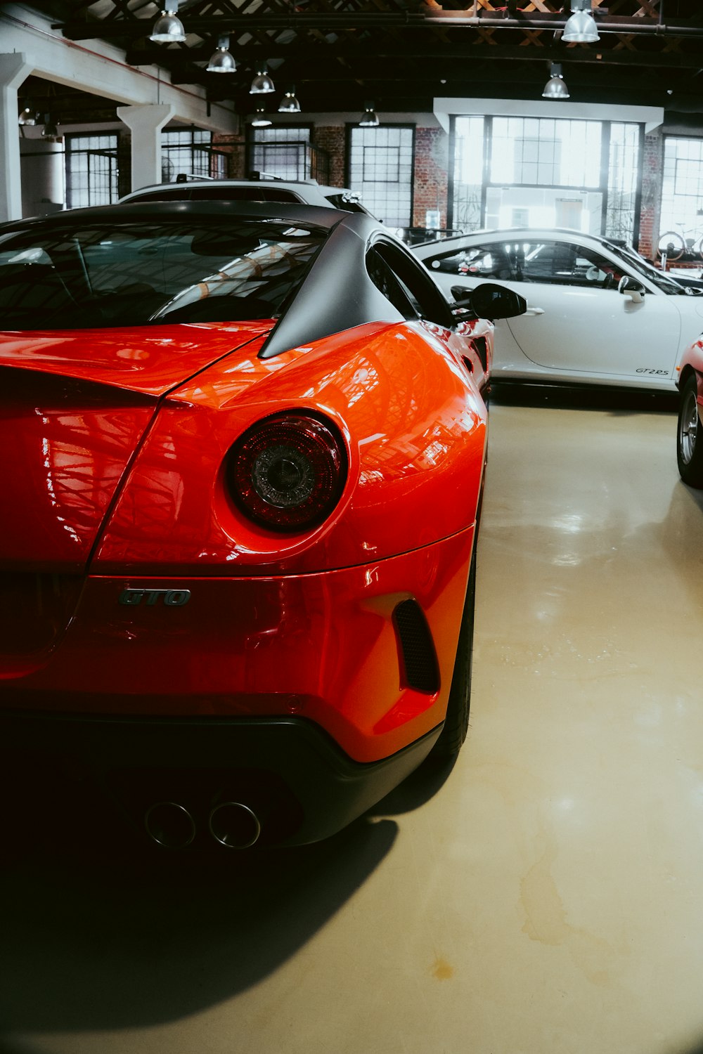 a couple of red sports cars parked in a garage