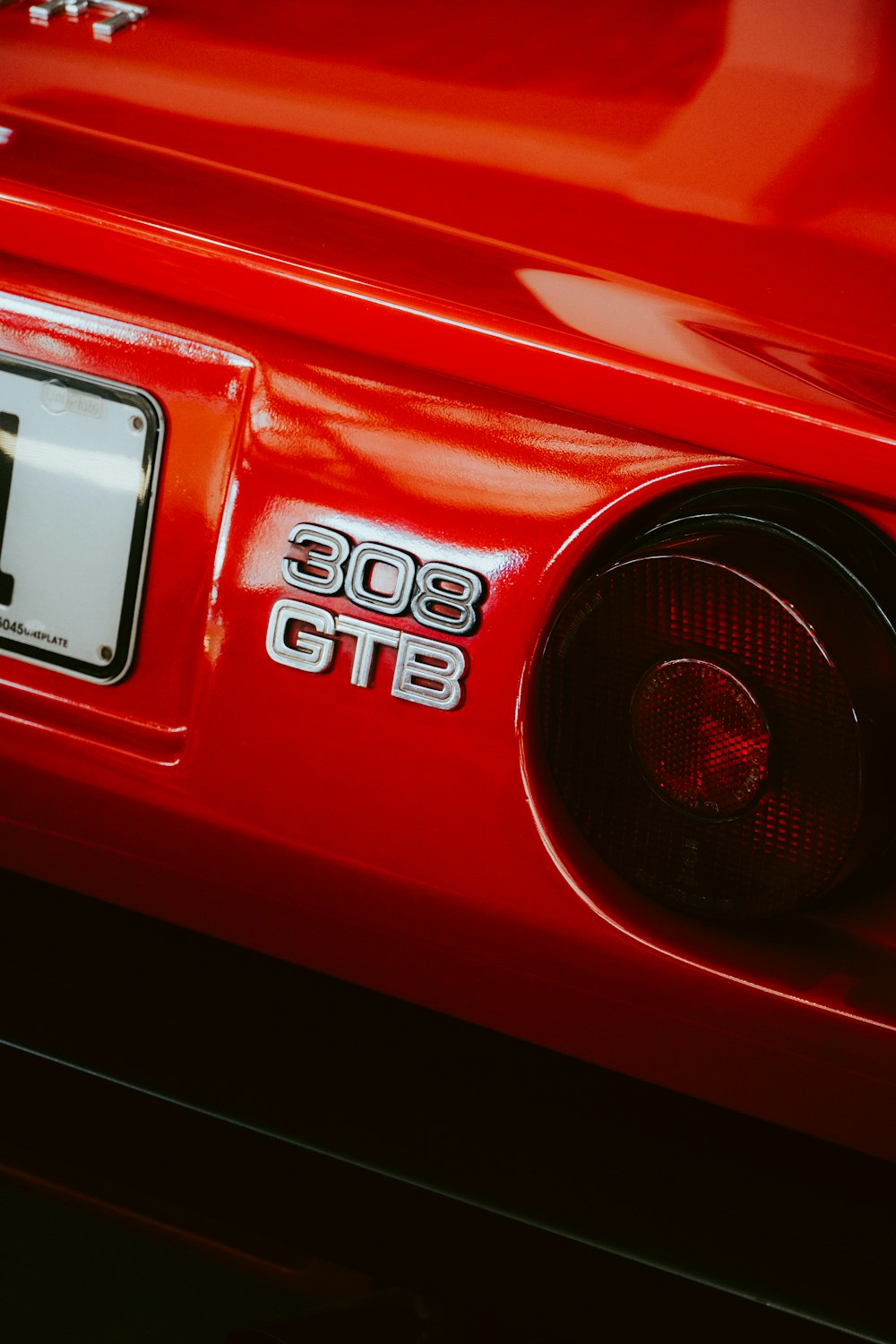 a close up of a red car with a number plate