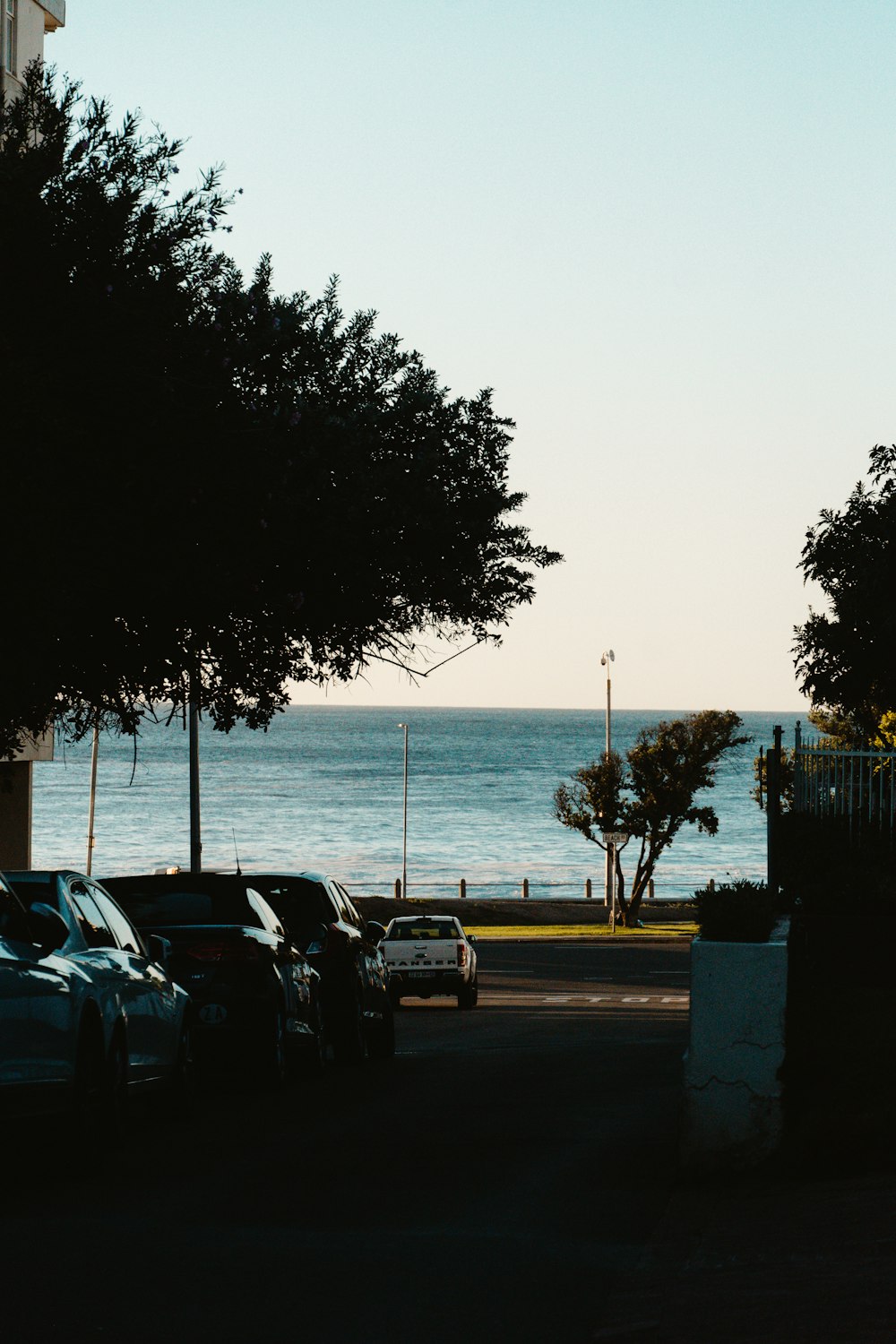 cars parked on the side of the road near the ocean