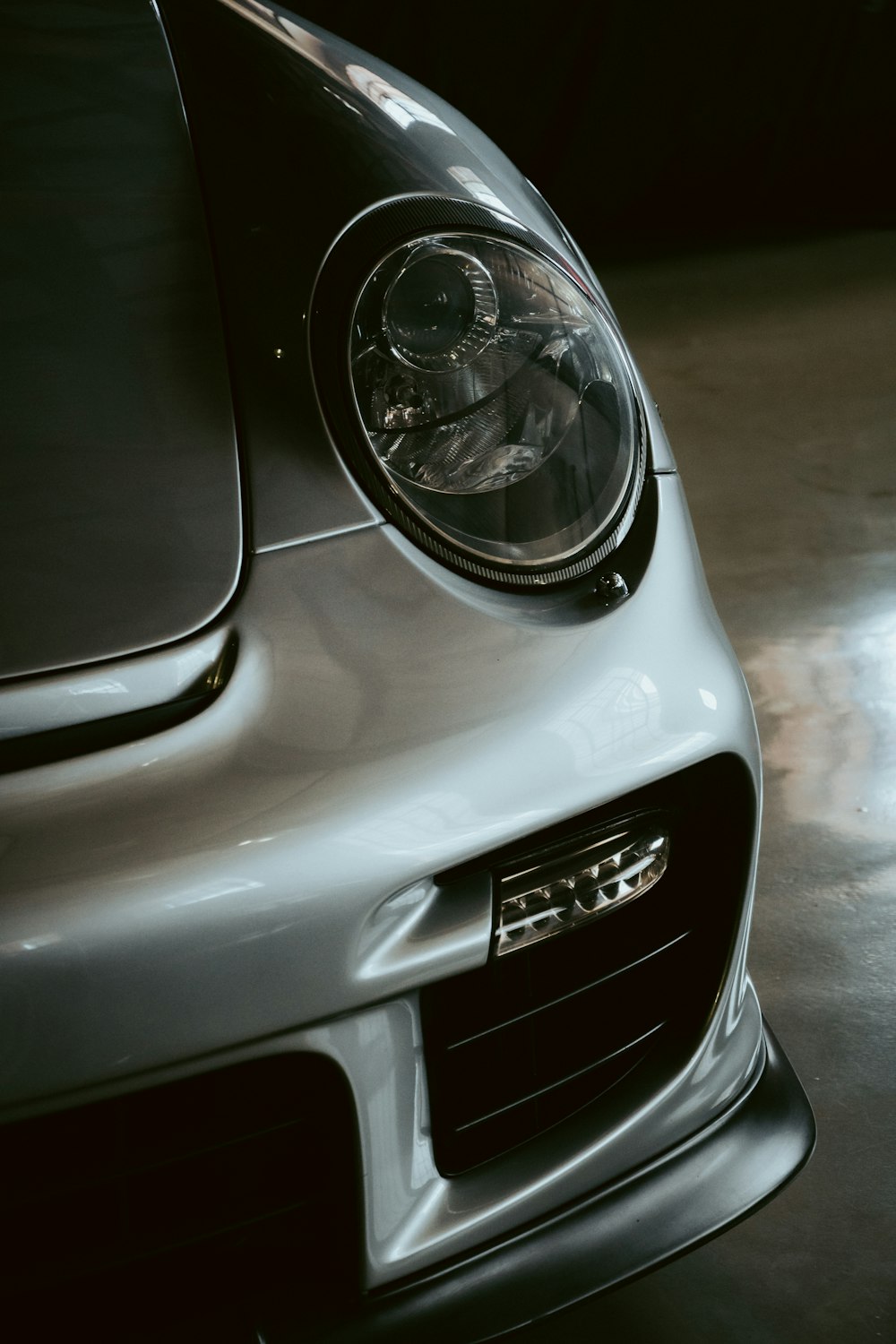 the front end of a silver sports car