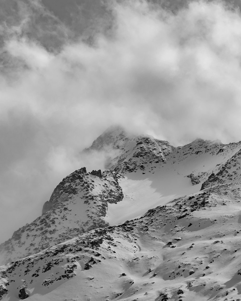 a black and white photo of a snow covered mountain