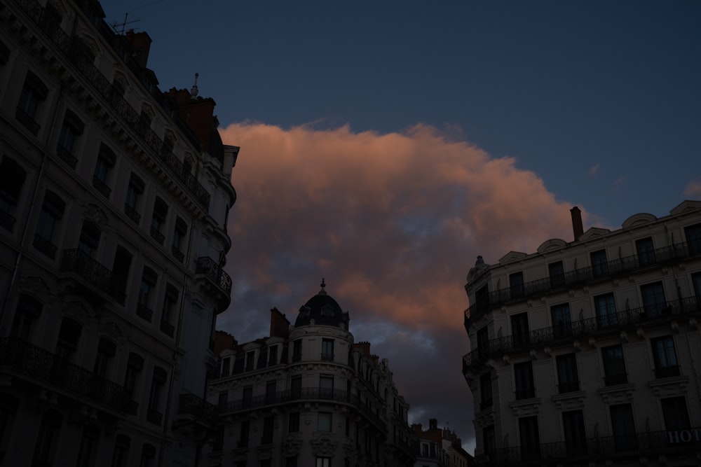 a very tall building next to a very cloudy sky