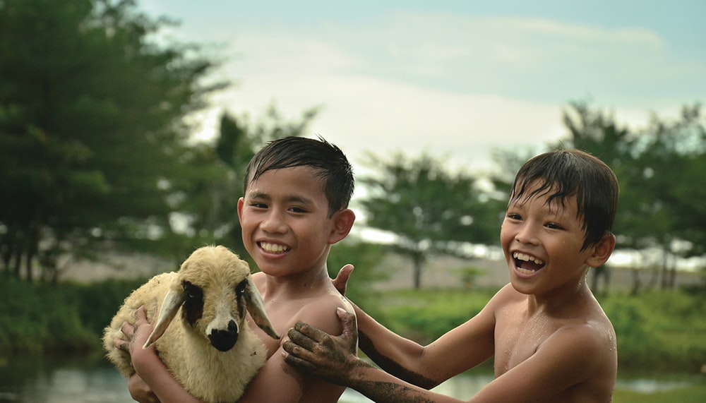 two young boys holding a stuffed animal in their hands