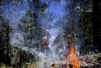 Ayahuasca Ceremony: Healing, Spiritual Benefits, a man standing in front of a fire in the woods