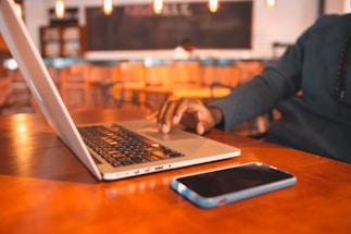 A person using a smartphone to send a message in a cozy workspace.
