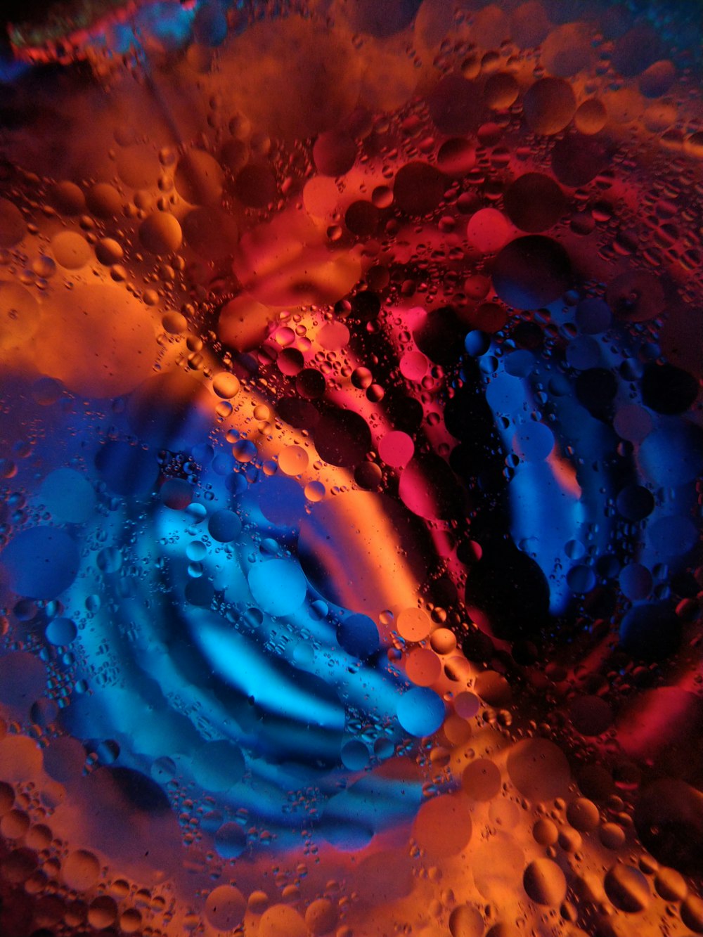 a close up of a liquid filled with blue and red colors