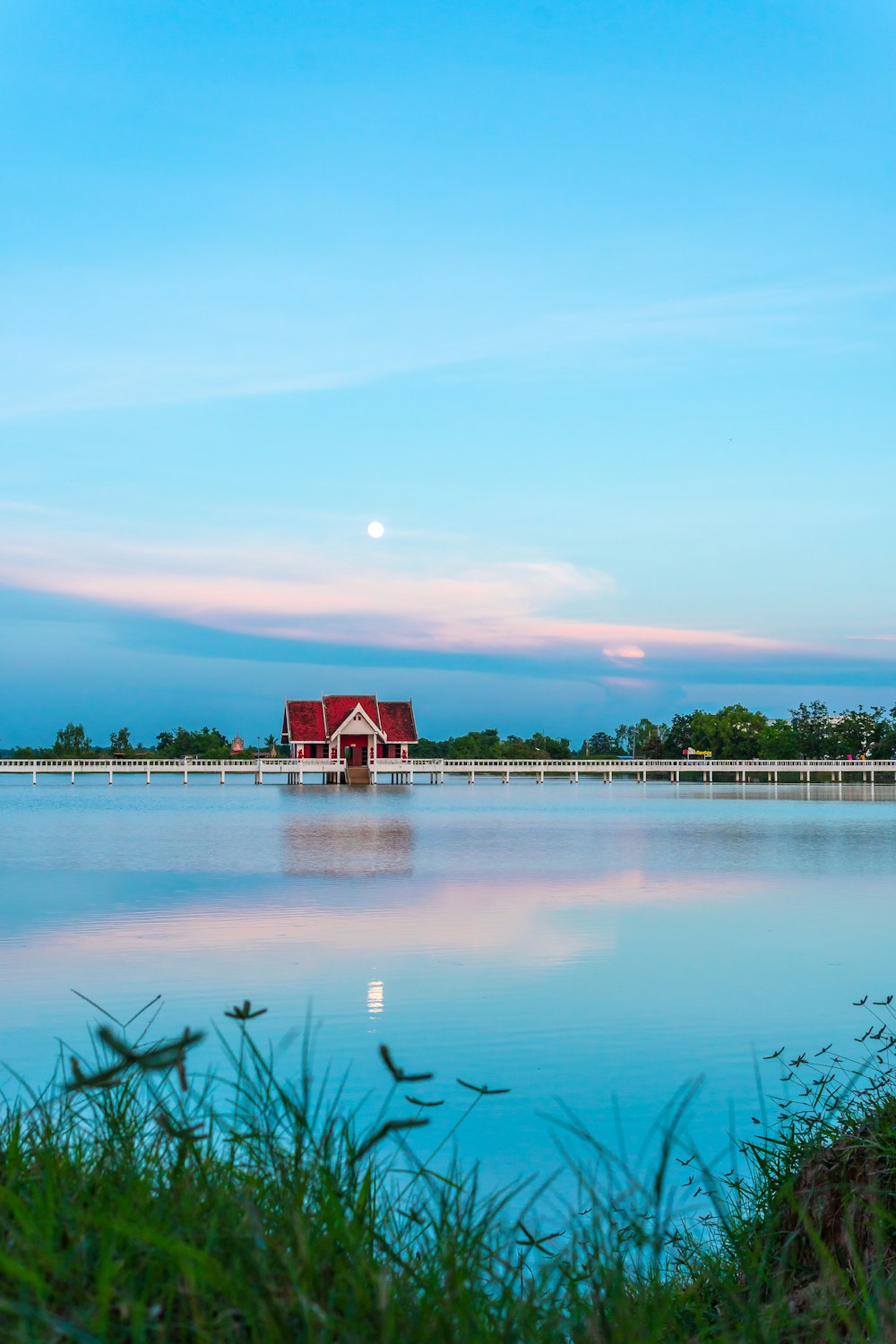 a large body of water with a red house in the background