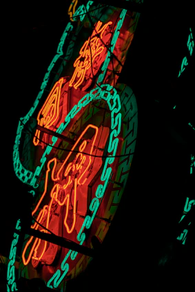 A creative team collaborating over design drafts with vibrant neon accents on a dark background.