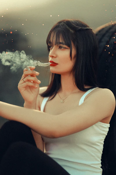 a woman sitting on a chair smoking a cigarette