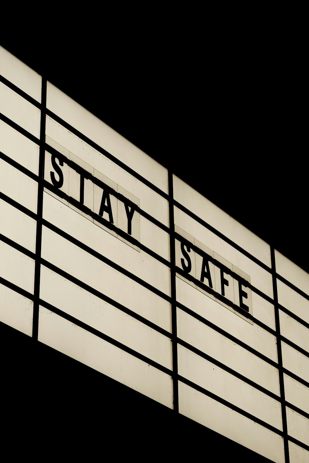 a black and white photo of a sign that says stay safe