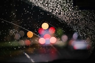 rain drops on the windshield of a car at night