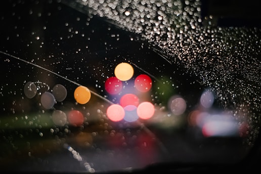 rain drops on the windshield of a car at night