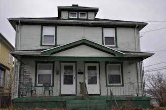 a two story house with a green front porch