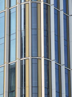 Close-up of a building’s facade featuring sharp, clean vertical elements reflecting sunlight.