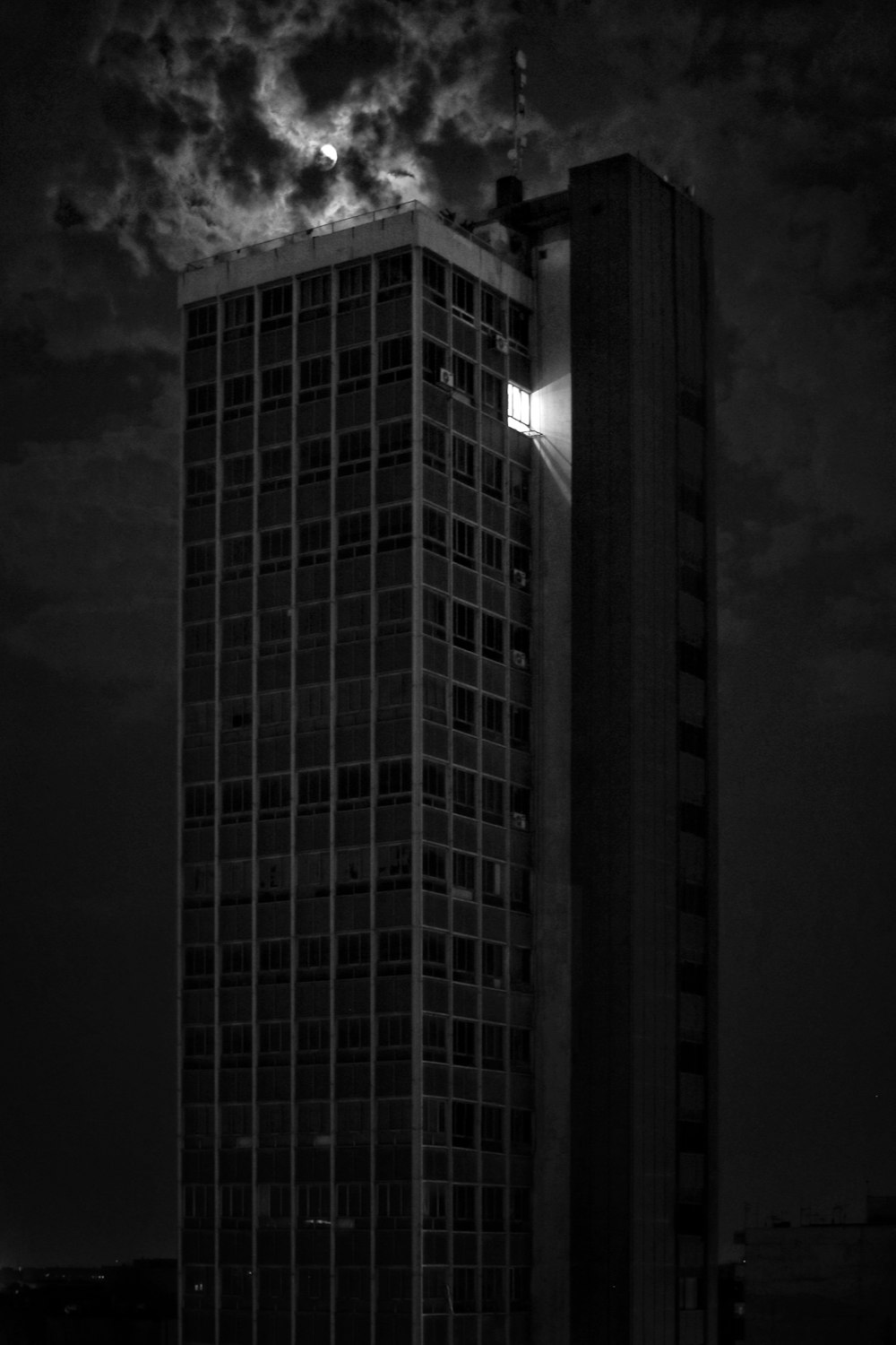 a tall building under a cloudy sky at night