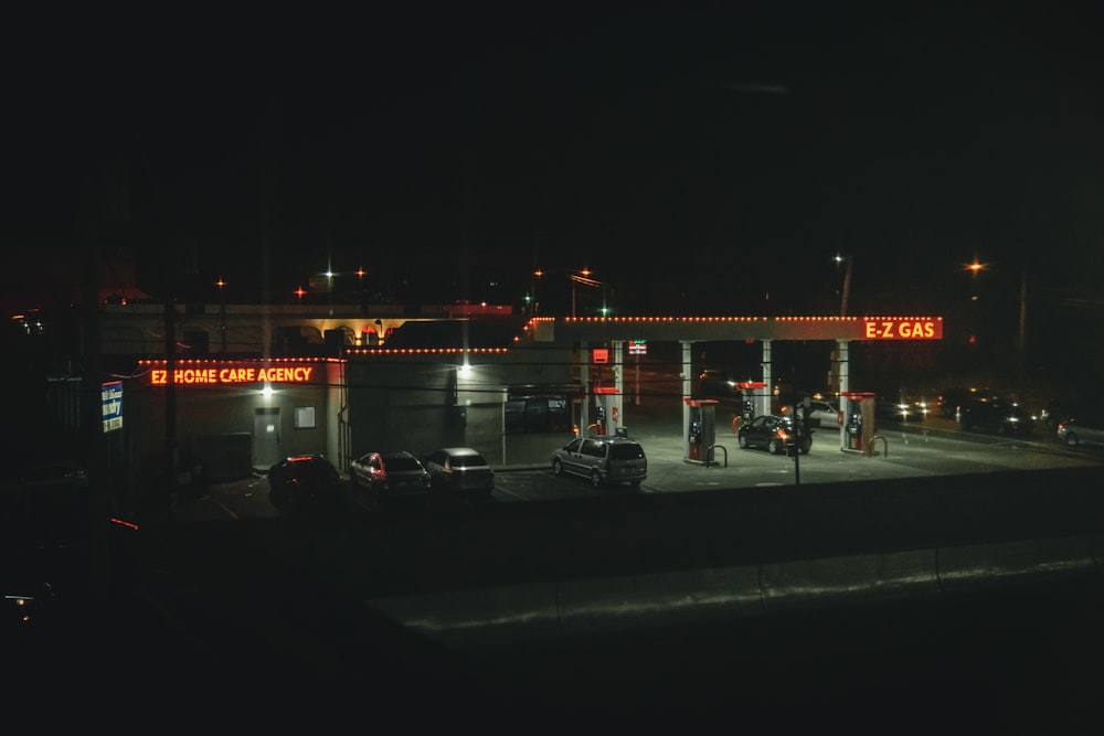 a gas station lit up at night time