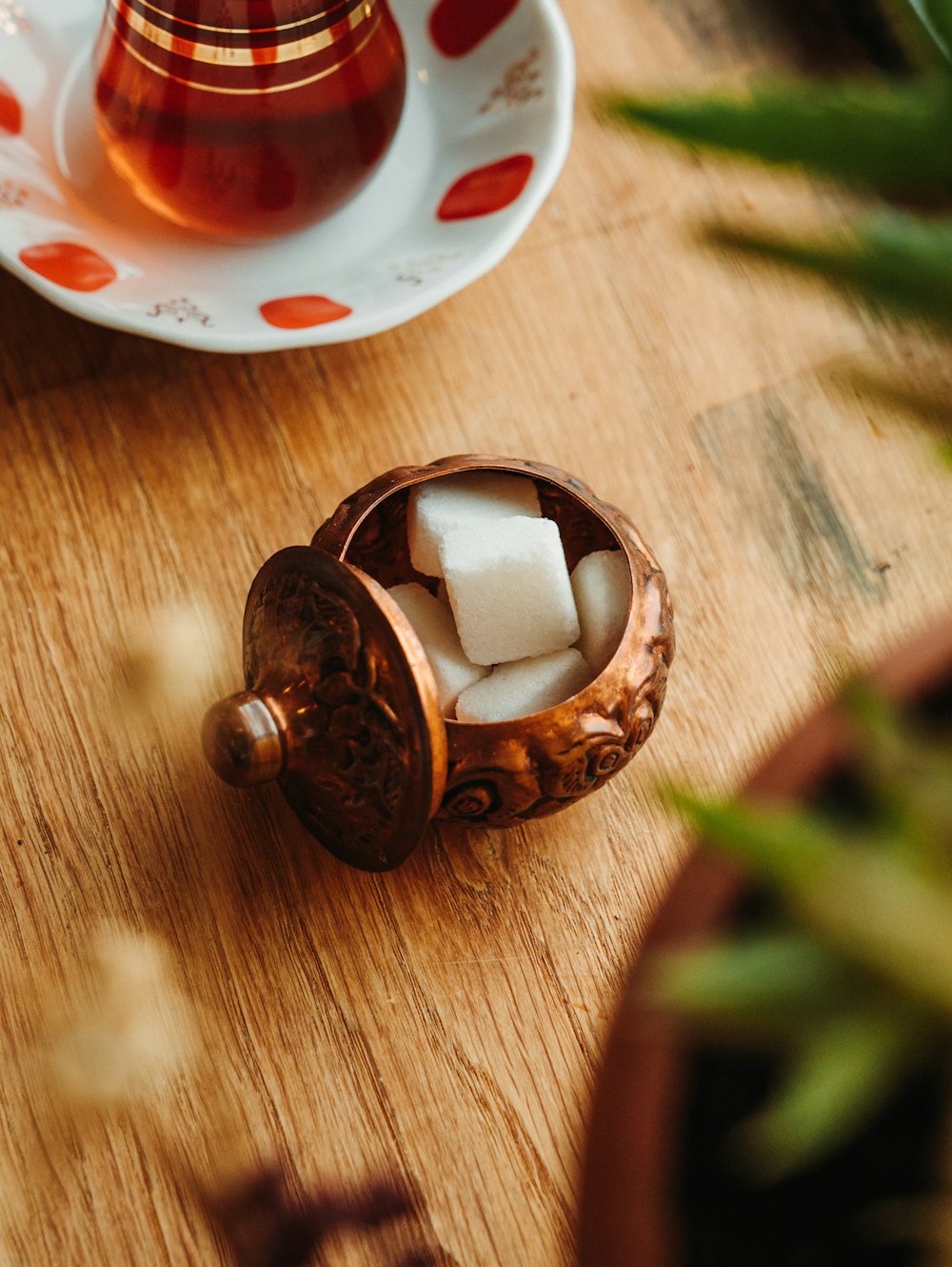 a wooden table topped with a cup filled with ice