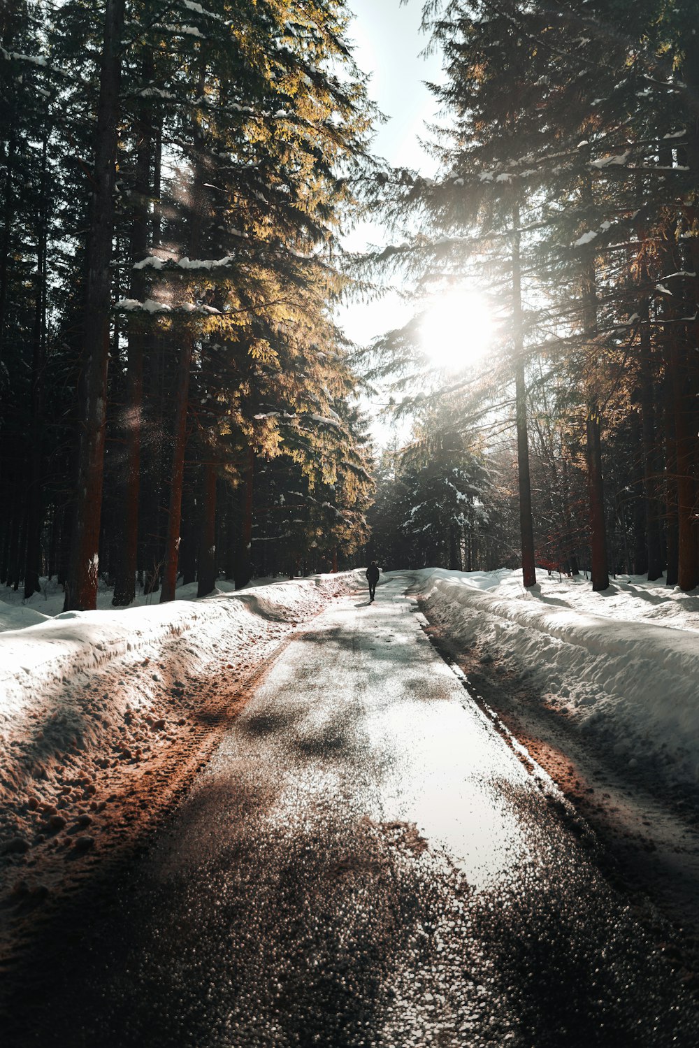 a person walking down a snow covered road