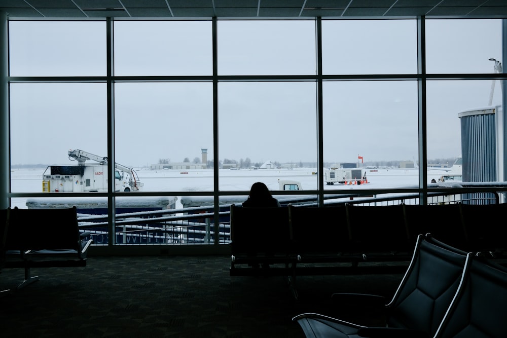 a person sitting on a bench looking out a window